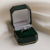 Diamond ring in a green jewelry box on a white fabric background